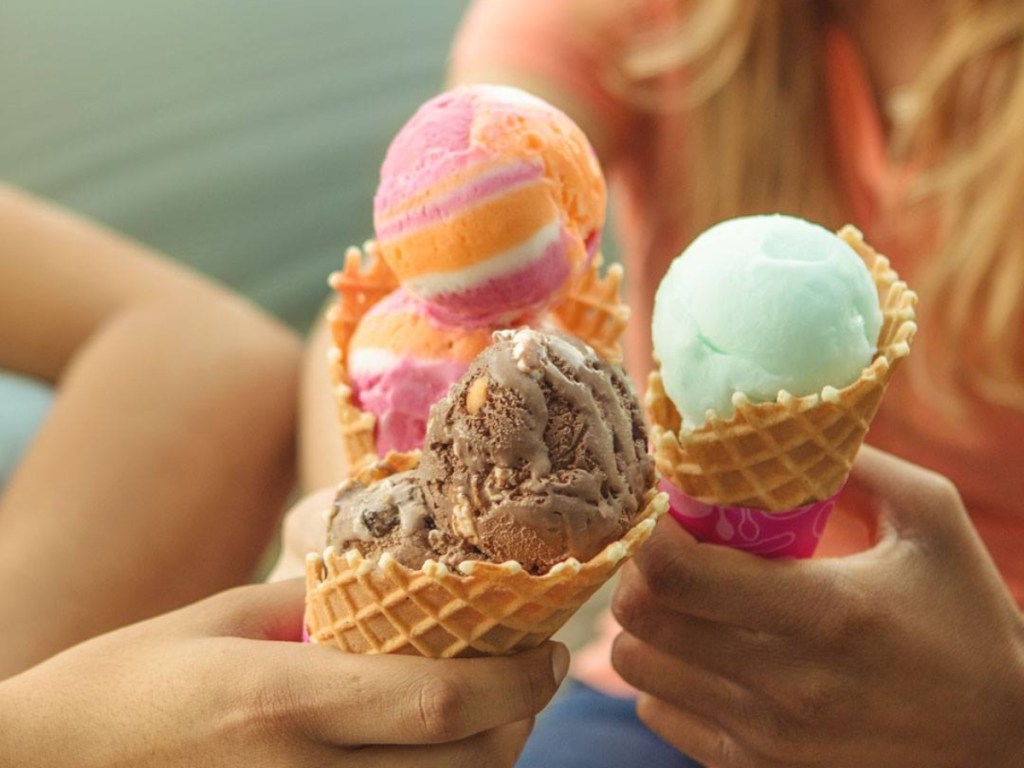 holding three ice cream cones