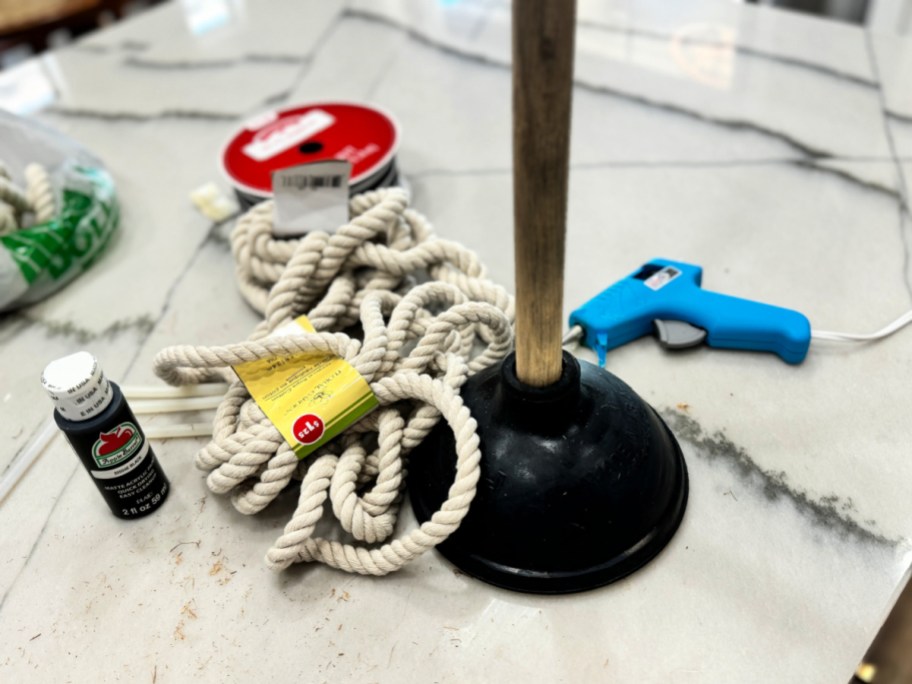 plunger with rope and hot glue gun on the counter