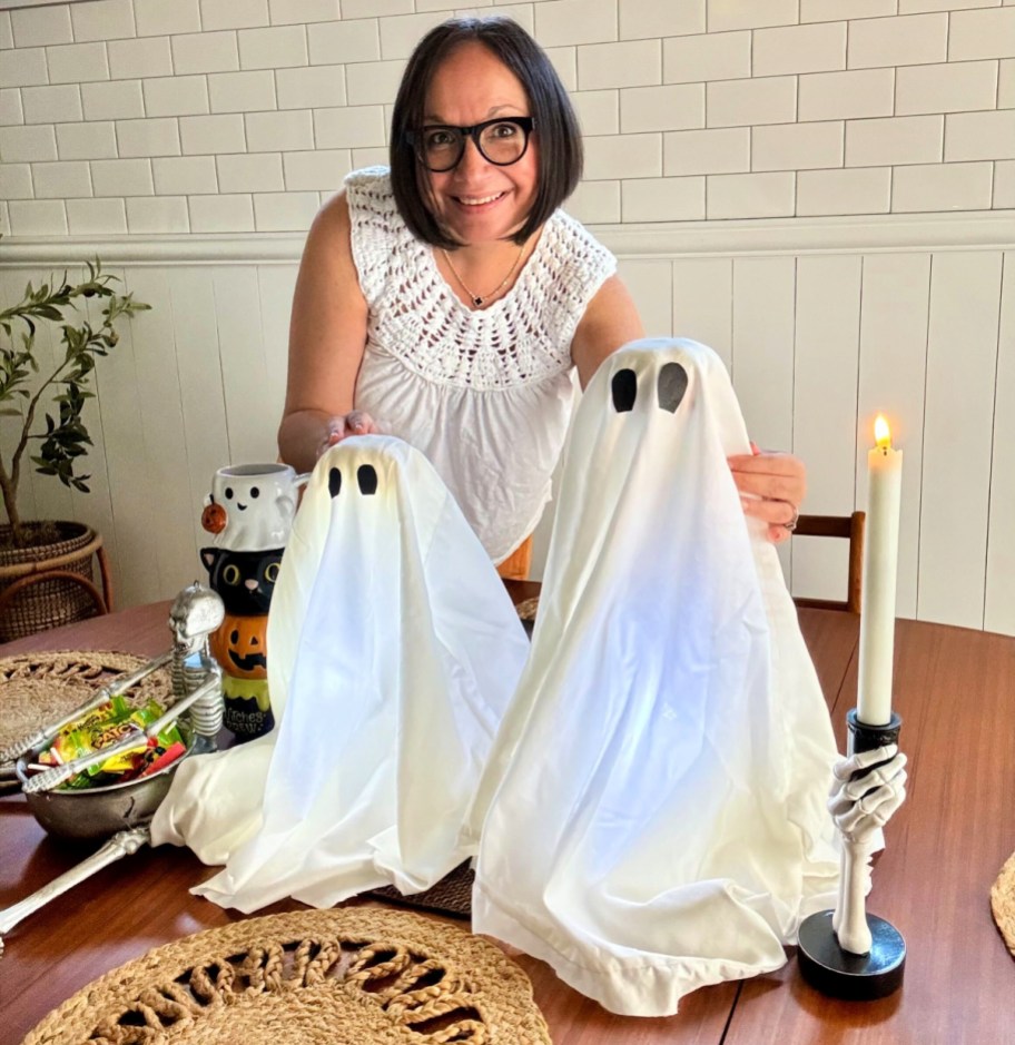 woman placing DIY ghost decor on a table